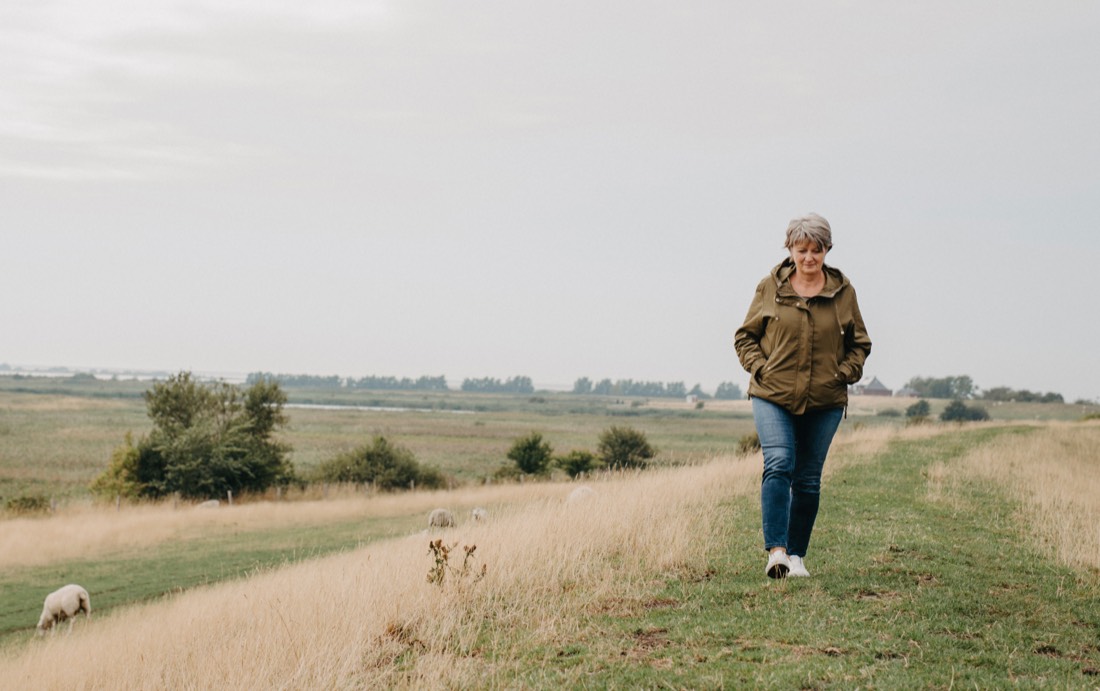 Frau spaziert durch die Pellwormer Landschaft